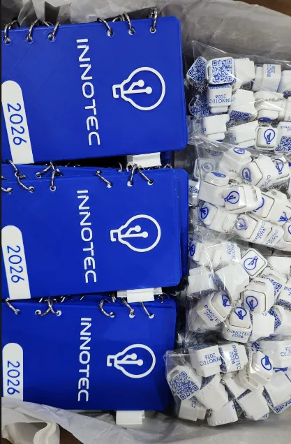 Caja con cuadernos corporativos y llaveros QR de INNOTEC UCA 2026, la serie completa lista para entregar a los asistentes.